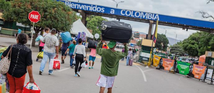 Venezuelan migrants are pictured carrying their bags as they cross the border into Colombia.