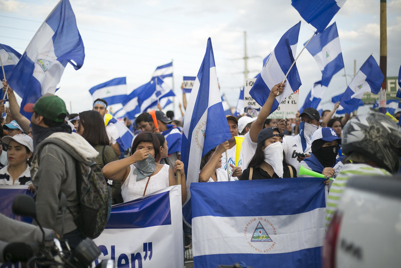 2018 protest in Nicaragua with protesters holding the blue and white Nicaraguan flag