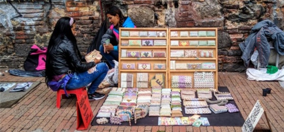 Venezuelan refugees in Bogotá are pictured selling crafts made of virtually worthless Venezuelan currency.