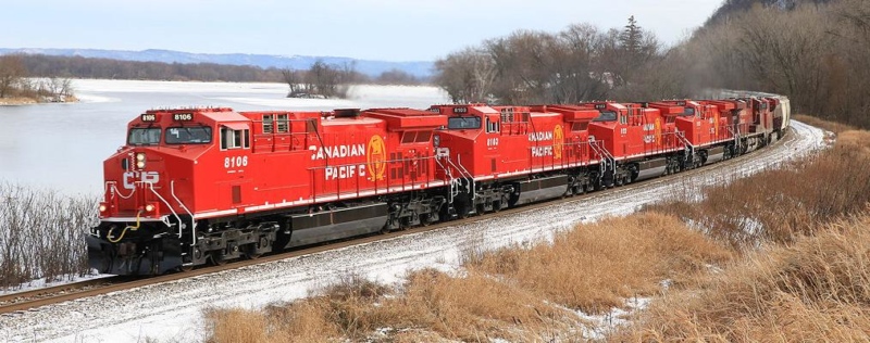 A red train is pictured against a landscape background.