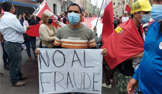A supporter of Pedro Castillo in Peru holding up a sign that says 