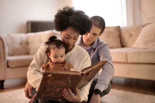Photo of parents reading to child