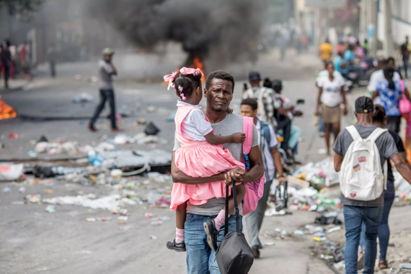 Photo of Haitian man carrying his daughter / Foto yon nonm ayisyen ki pote pitit fi li / Photo d'un homme haïtien qui transport sa fille