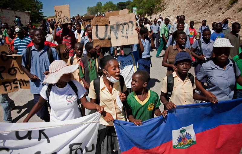 Photo of Haitian protesters holding up sign saying "UN?"