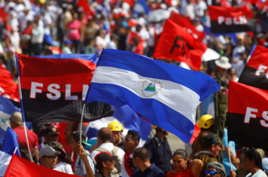 Photo of Nicaraguan flag with flags from the Frente Sandinista de Liberación Nacional (FSLN) party