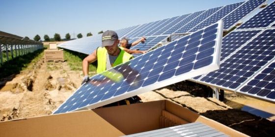Photo of a worker installing solar panels